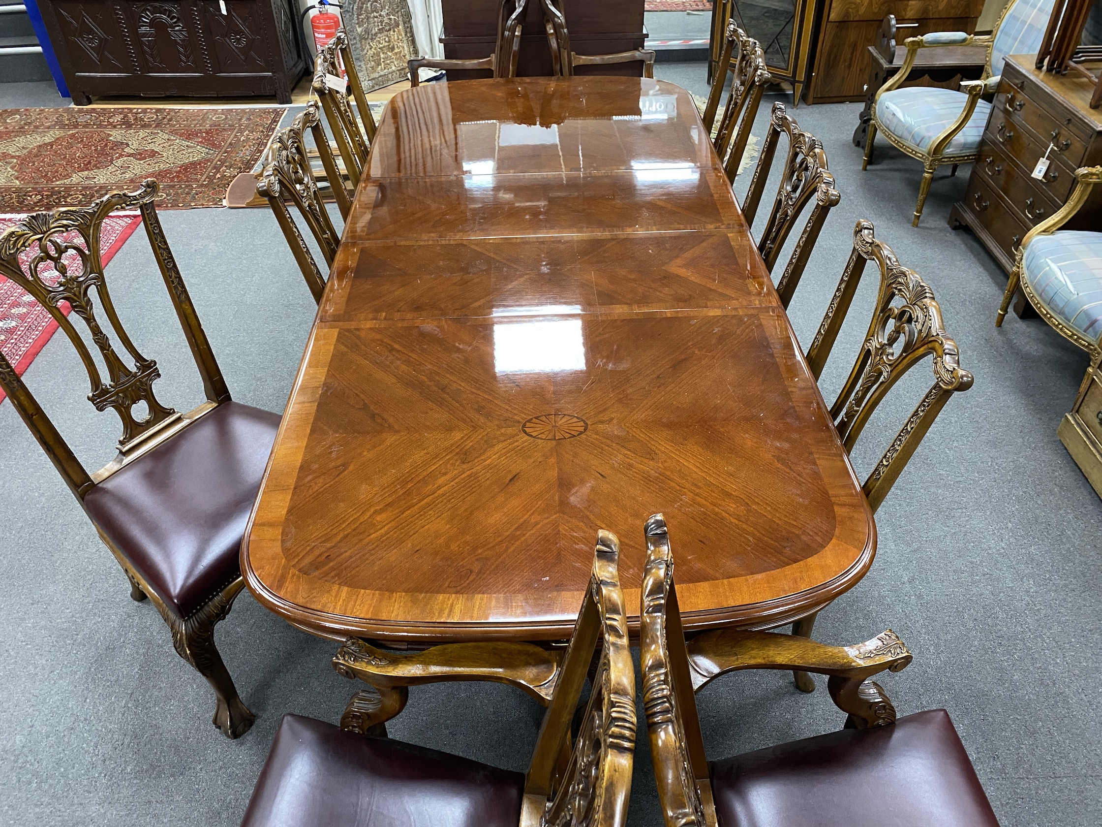 A reproduction inlaid mahogany twin pillar extending dining table, approx. 250cm extended, two spare leaves, width 110cm, height 75cm, together with eight Chippendale style mahogany dining chairs, two with arms